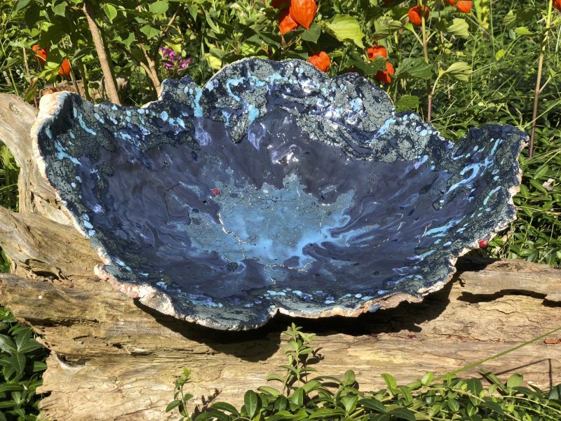 blue ceramic bowl on log