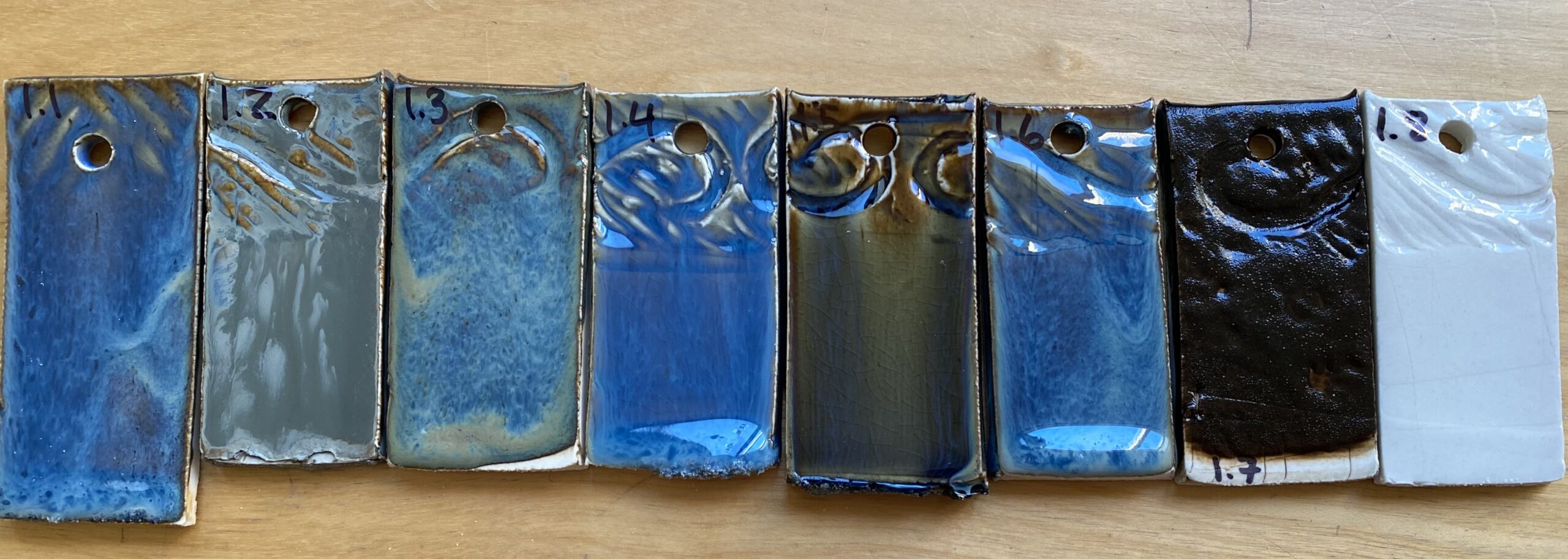 Glaze test tiles showing a range of blues and blacks after firing